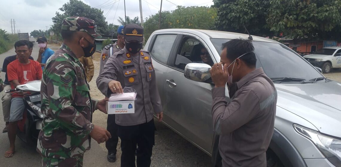 Kapolsek Tapung Hulu Bersama Aparatur Desa dan Babinsa Bagikan Masker di Desa Kasikan
