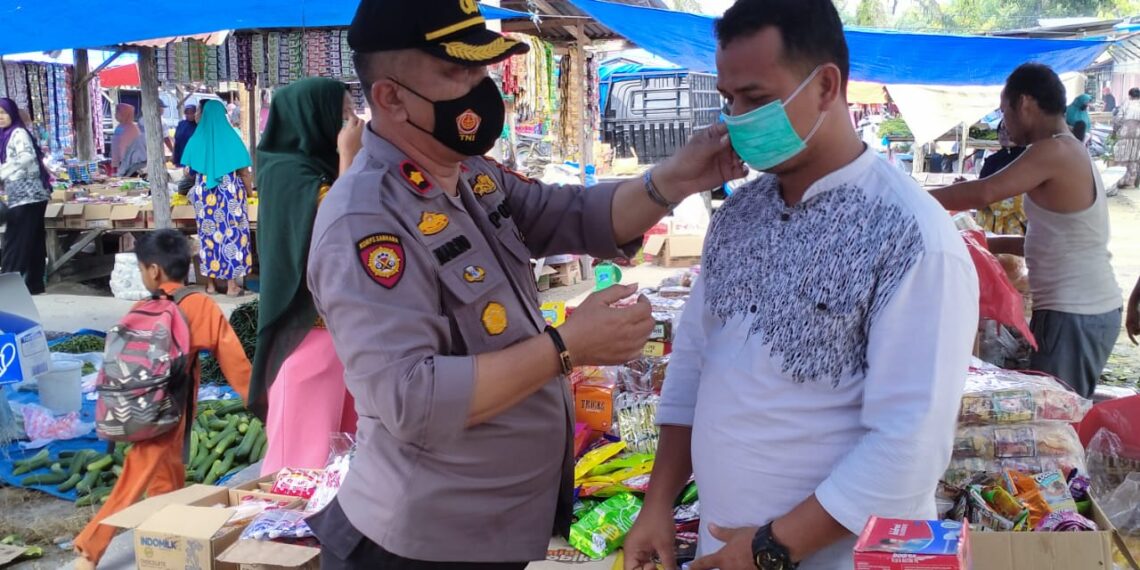 Kapolsek Tapung Pimpin Pendisiplinan Protkes dan Bagikan Masker di Pasar Muara Mahat Baru