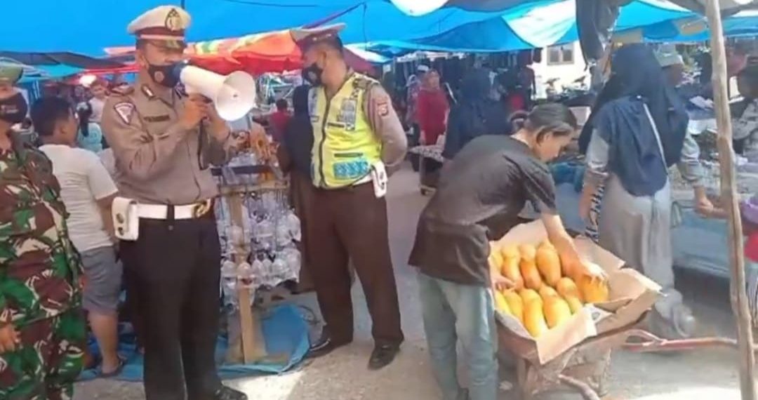 Kasat Lantas Polres Kampar Himbau Warga Patuhi Protkes dan Bagikan Masker di Pasar Air Tiris