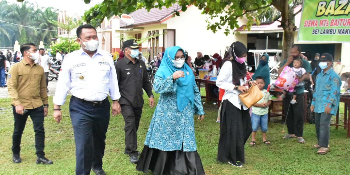 Pilkades Serentak, Bupati Kampar dan Isteri Lakukan Pencoblosan di TPS 22 Sei Lembu Makmur.