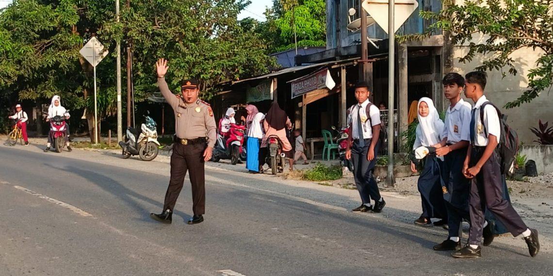 Kapolsek Kampar Turun Langsung Atur Arus Lalu Lintas Pagi dan Seberangkan Anak Sekolah