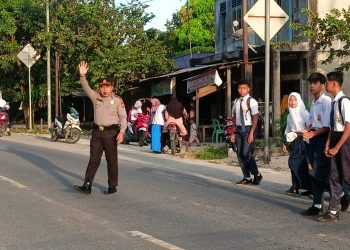 Kapolsek Kampar Turun Langsung Atur Arus Lalu Lintas Pagi dan Seberangkan Anak Sekolah